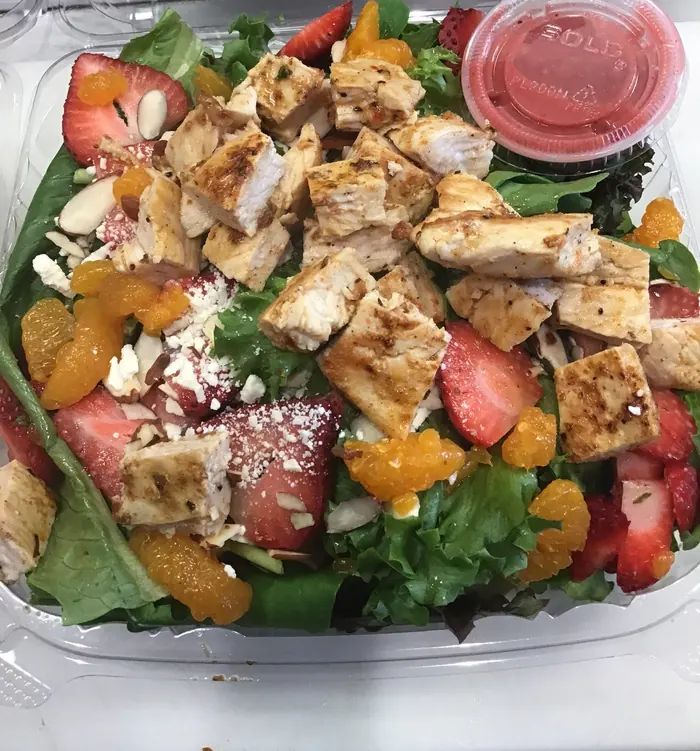 Grilled chicken salad with strawberries, mandarin oranges, almonds and crumbled cheese, packed to go